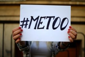 Young woman with painted nails holding a #metoo sign