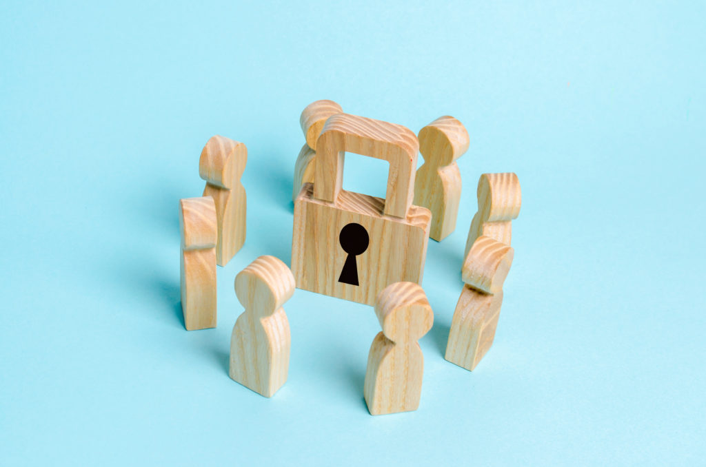 Wooden lock surrounded by wooden people to depict HIPAA Security
