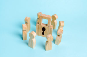 Wooden lock surrounded by wooden people to depict HIPAA Security