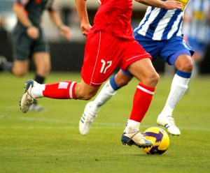 Close-up image of two soccer players playing on a field