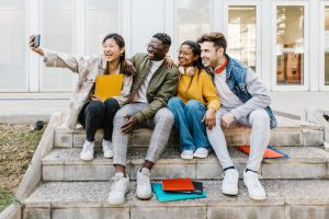 Happy young group of multiracial students taking selfie portrait together at campus high school